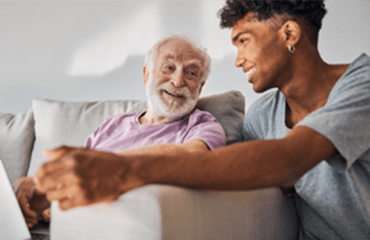 Elderly man sitting with young black man