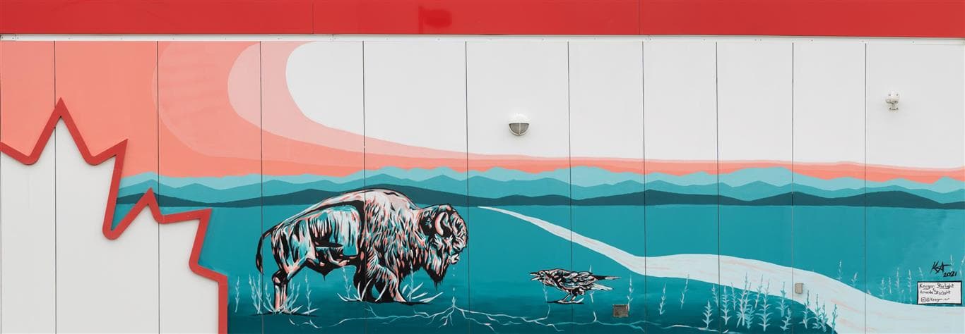 A mural by Keegan Starlight, depicting buffalo and other animals, painted on the side of a Petro-Canada station
