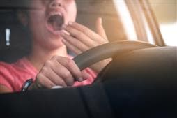Woman yawning while driving car