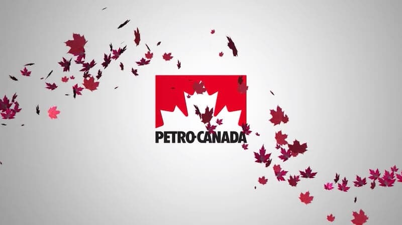 Des feuilles d'érable rouges qui volent devant le logo Petro-Canada.