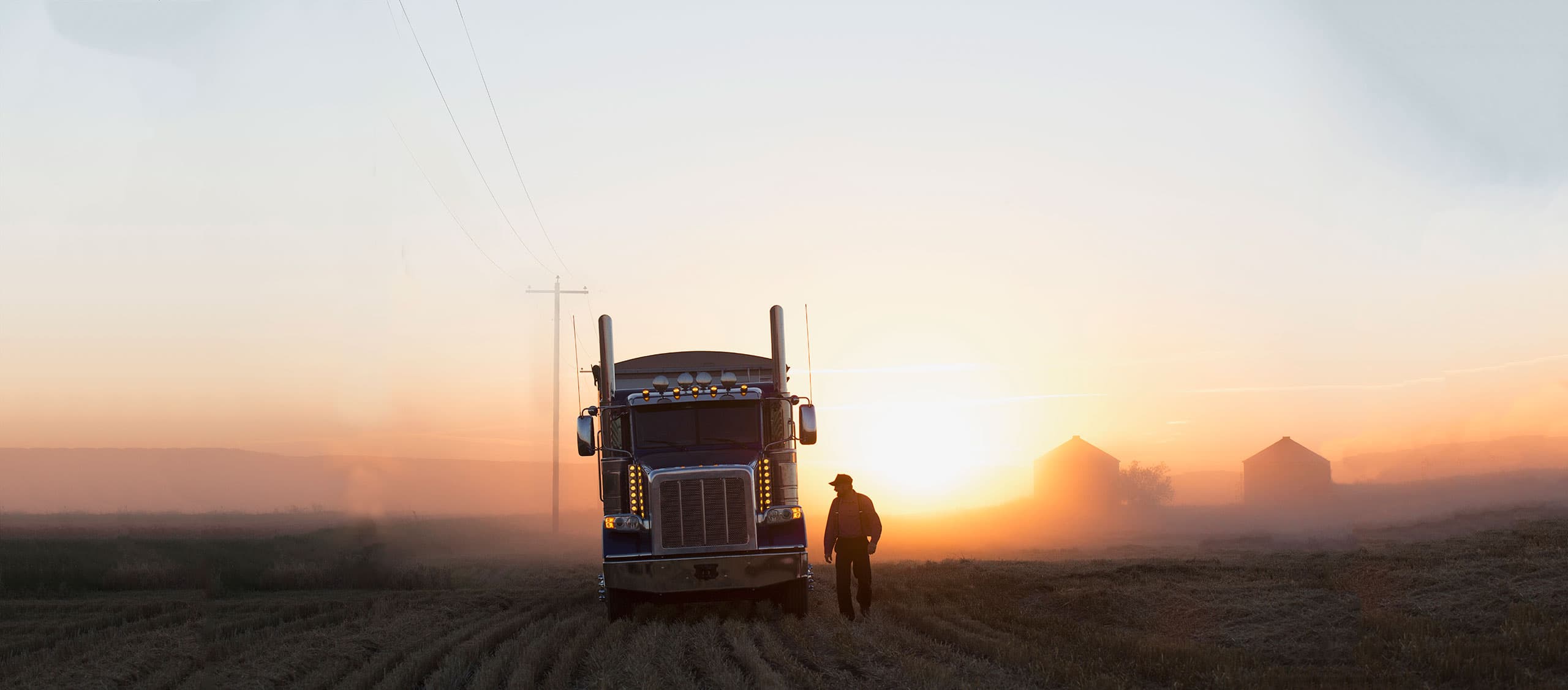 Rig and driver at dusk in a field.