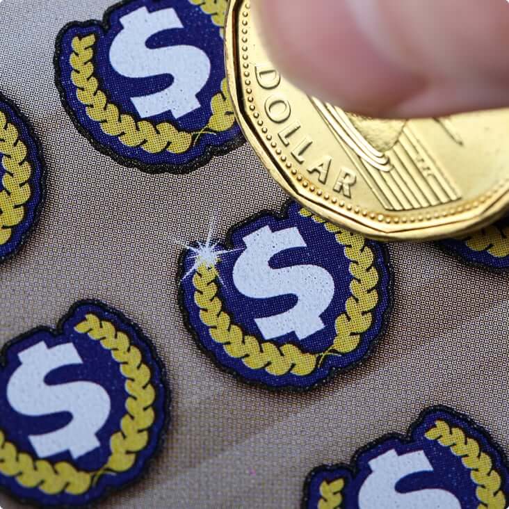 A loonie scratching a lottery ticket
