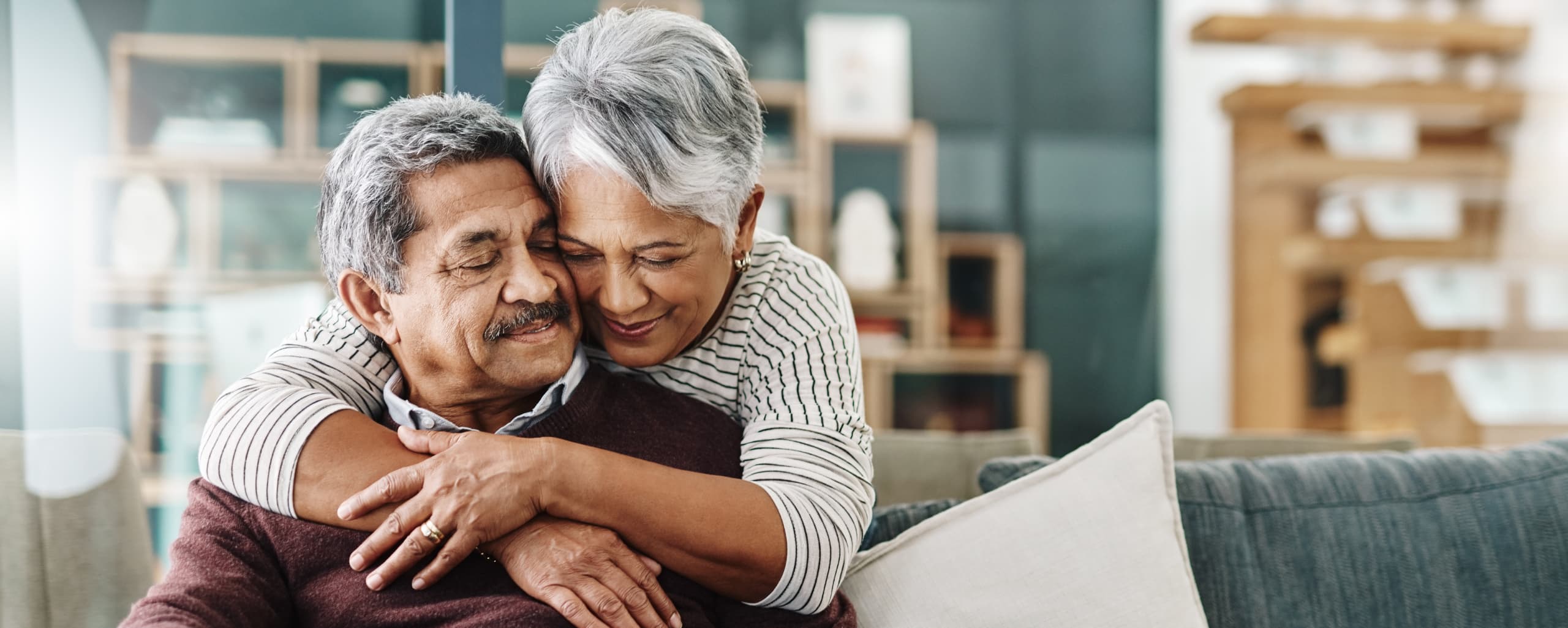A family caregiver wrapping her arms around her spouse.
