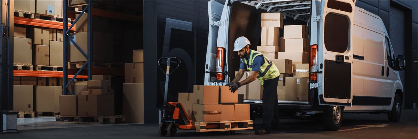 Worker loading boxes into a white van