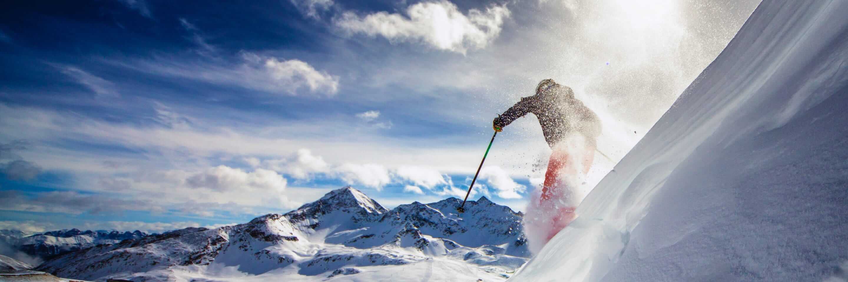Un skieur que descend une pente abrupte.